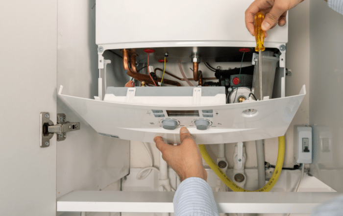 A technician installing a boiler, highlighting the benefits of proper boiler installation.